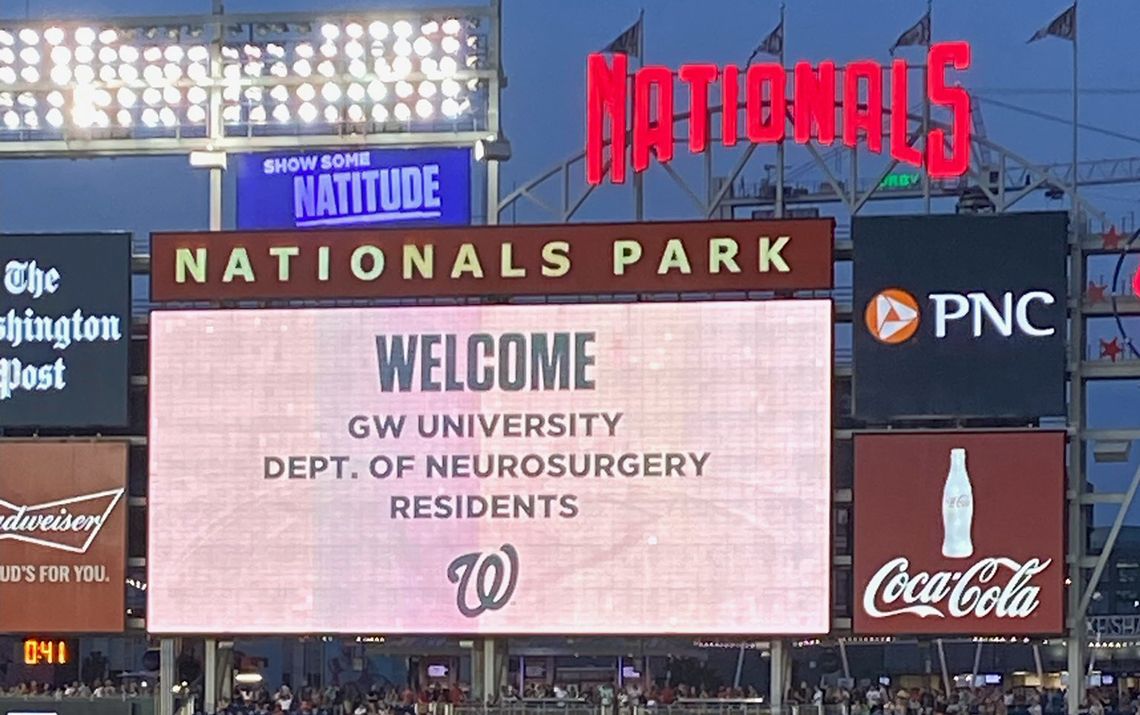 Big screen at Nationals' stadium that reads "Welcome GW University Dept of Neurosurgery Residents"